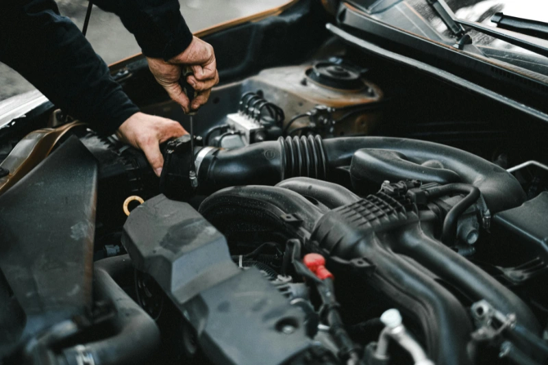 Mechanic performing minor car service in Parramatta, checking engine components under the bonnet